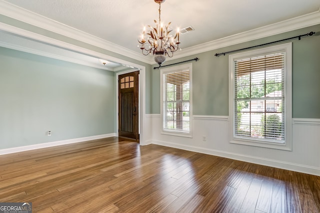 unfurnished room with crown molding, hardwood / wood-style floors, and a notable chandelier