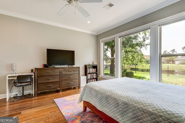 bedroom with multiple windows, ceiling fan, ornamental molding, and light hardwood / wood-style flooring