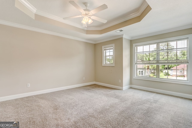 carpeted empty room with crown molding, ceiling fan, and a tray ceiling