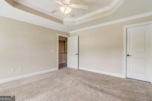 interior space featuring ceiling fan, ornamental molding, and a tray ceiling