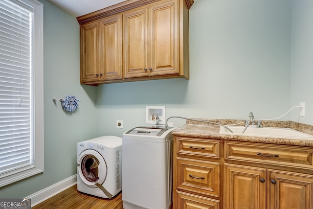 laundry area featuring cabinets, sink, hookup for an electric dryer, hardwood / wood-style flooring, and washer hookup