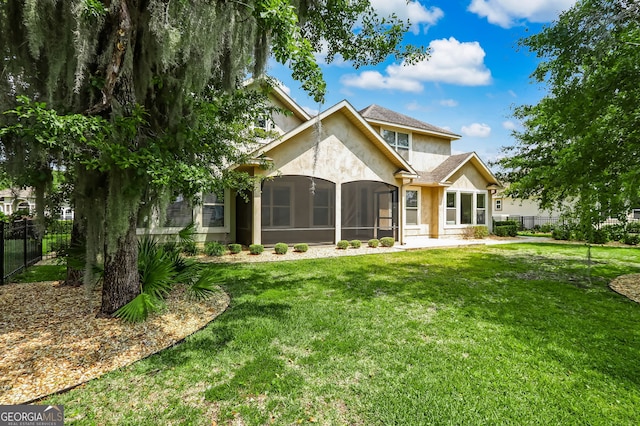 rear view of property with a sunroom and a yard