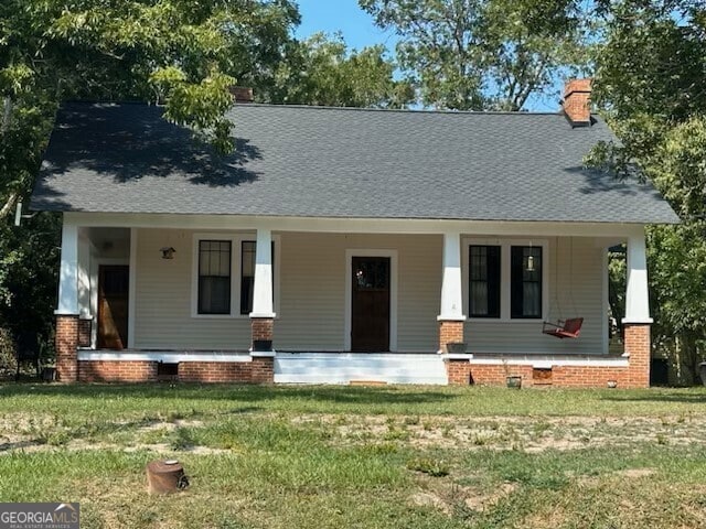 view of front facade featuring a front yard and covered porch