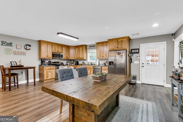 kitchen with appliances with stainless steel finishes, hardwood / wood-style flooring, and sink