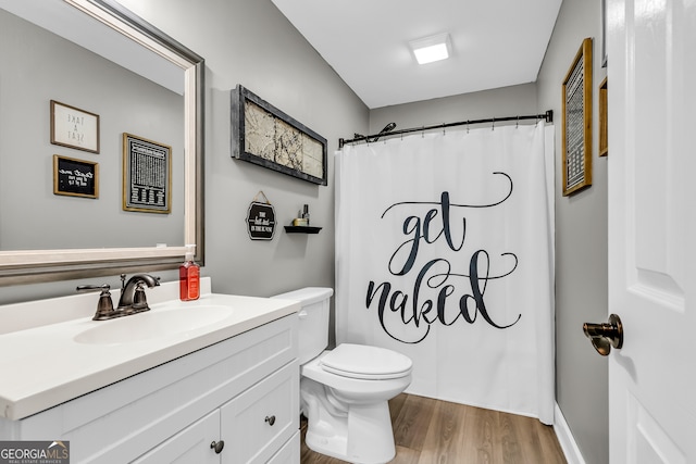 bathroom featuring a shower with shower curtain, toilet, hardwood / wood-style flooring, and vanity