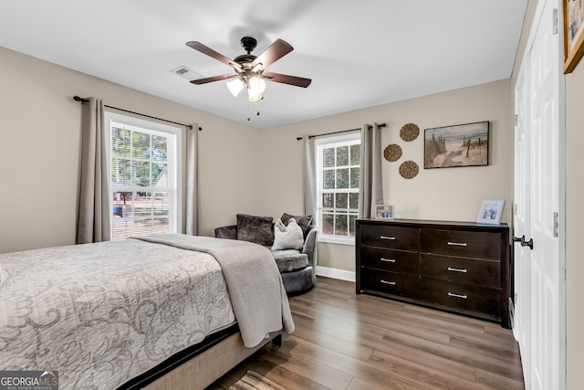 bedroom featuring multiple windows, ceiling fan, and light hardwood / wood-style flooring