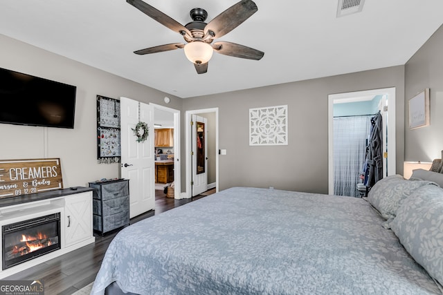 bedroom with dark hardwood / wood-style flooring, ceiling fan, a closet, a walk in closet, and ensuite bathroom