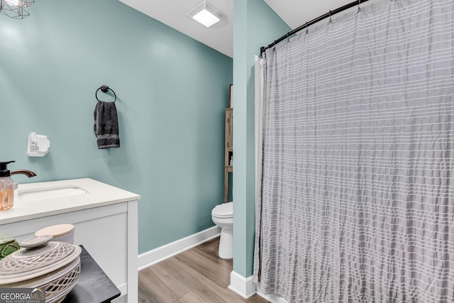 bathroom with vanity, toilet, hardwood / wood-style floors, and curtained shower