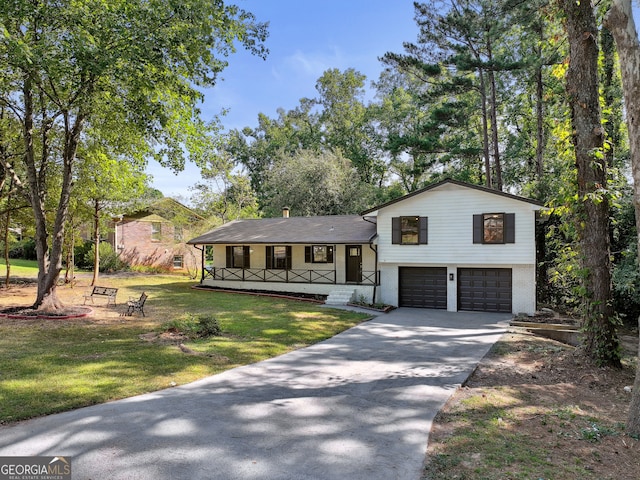 tri-level home featuring a garage, a porch, and a front lawn