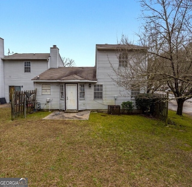 back of property with a lawn and a patio area