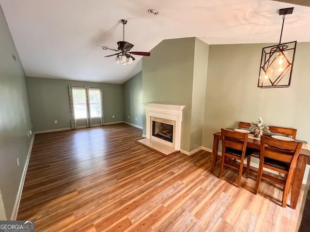 living room featuring light hardwood / wood-style flooring, vaulted ceiling, and ceiling fan