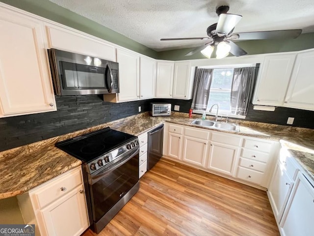 kitchen featuring white cabinets, sink, stainless steel appliances, and ceiling fan