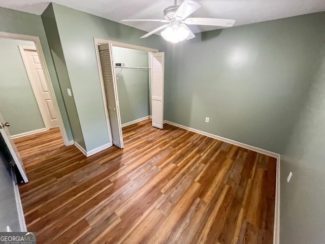 unfurnished bedroom featuring ceiling fan, a closet, and hardwood / wood-style flooring