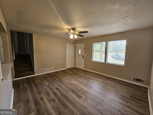 empty room with ceiling fan, dark hardwood / wood-style flooring, and a textured ceiling