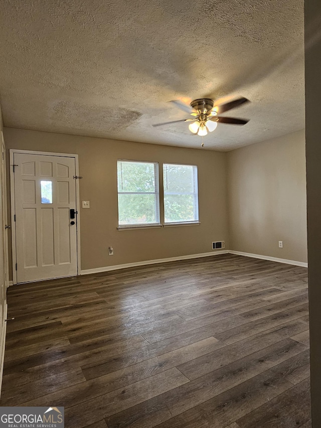 foyer featuring a textured ceiling, ceiling fan, and dark wood-type flooring