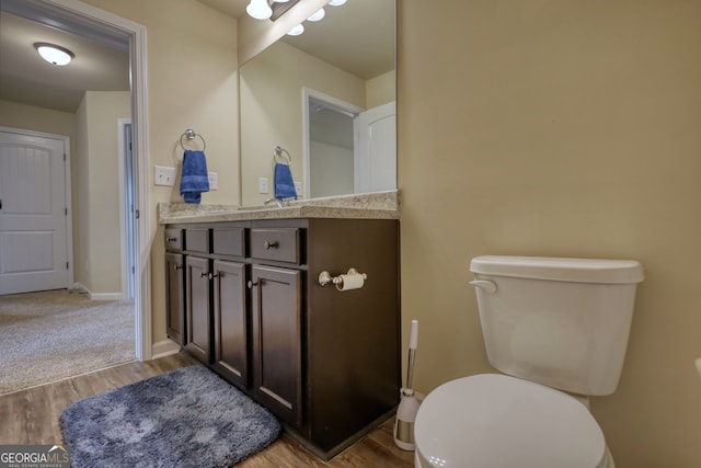 bathroom with vanity, toilet, and hardwood / wood-style flooring