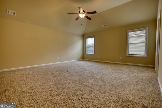 empty room with light carpet, vaulted ceiling, a wealth of natural light, and ceiling fan