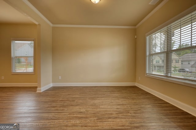 empty room featuring crown molding and wood-type flooring