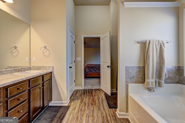 bathroom with vanity, a bath, and hardwood / wood-style floors