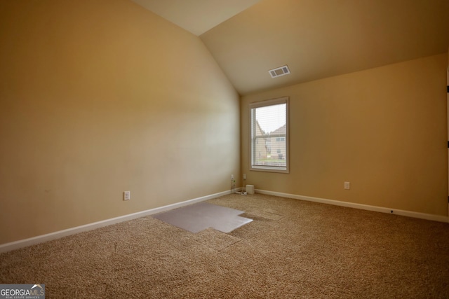 unfurnished room featuring carpet and vaulted ceiling