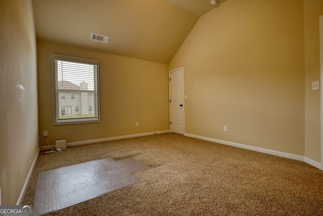 carpeted empty room featuring lofted ceiling