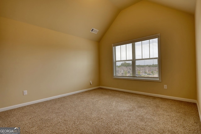 spare room featuring lofted ceiling and light carpet