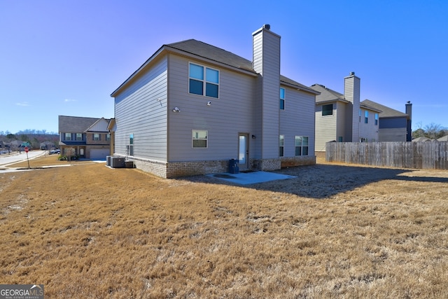 rear view of property featuring central air condition unit and a yard