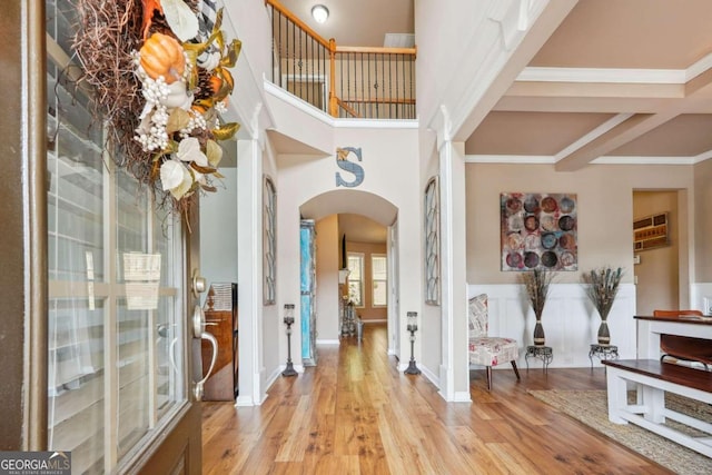 foyer entrance with crown molding and light hardwood / wood-style floors