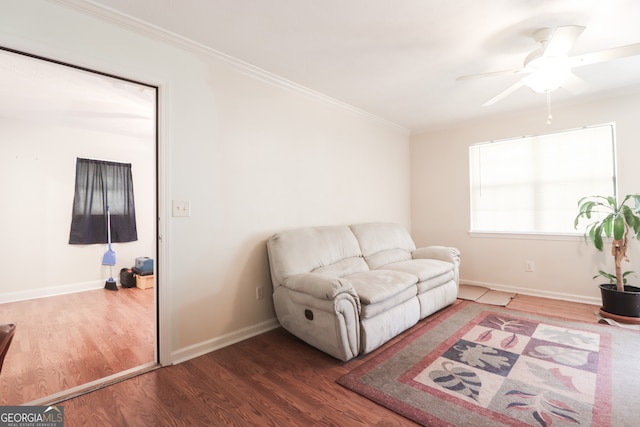 living room featuring crown molding, wood-type flooring, and ceiling fan