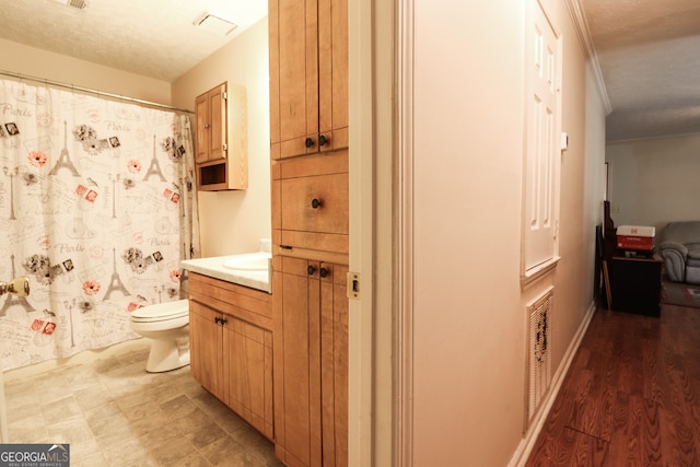 bathroom featuring toilet, vanity, a textured ceiling, wood-type flooring, and a shower with shower curtain