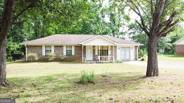 single story home featuring covered porch and a front lawn