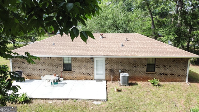 rear view of property featuring cooling unit, a yard, and a patio area