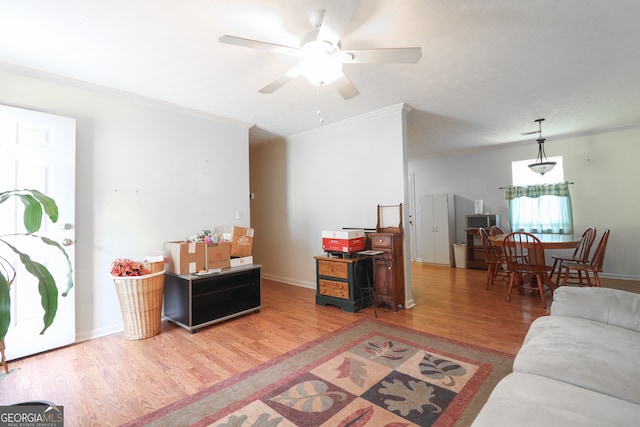 living room with hardwood / wood-style floors, ceiling fan, and ornamental molding