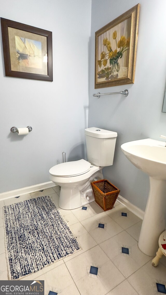 bathroom featuring sink, tile patterned floors, and toilet