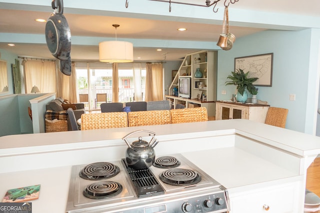 kitchen with hardwood / wood-style flooring, hanging light fixtures, and stainless steel range oven