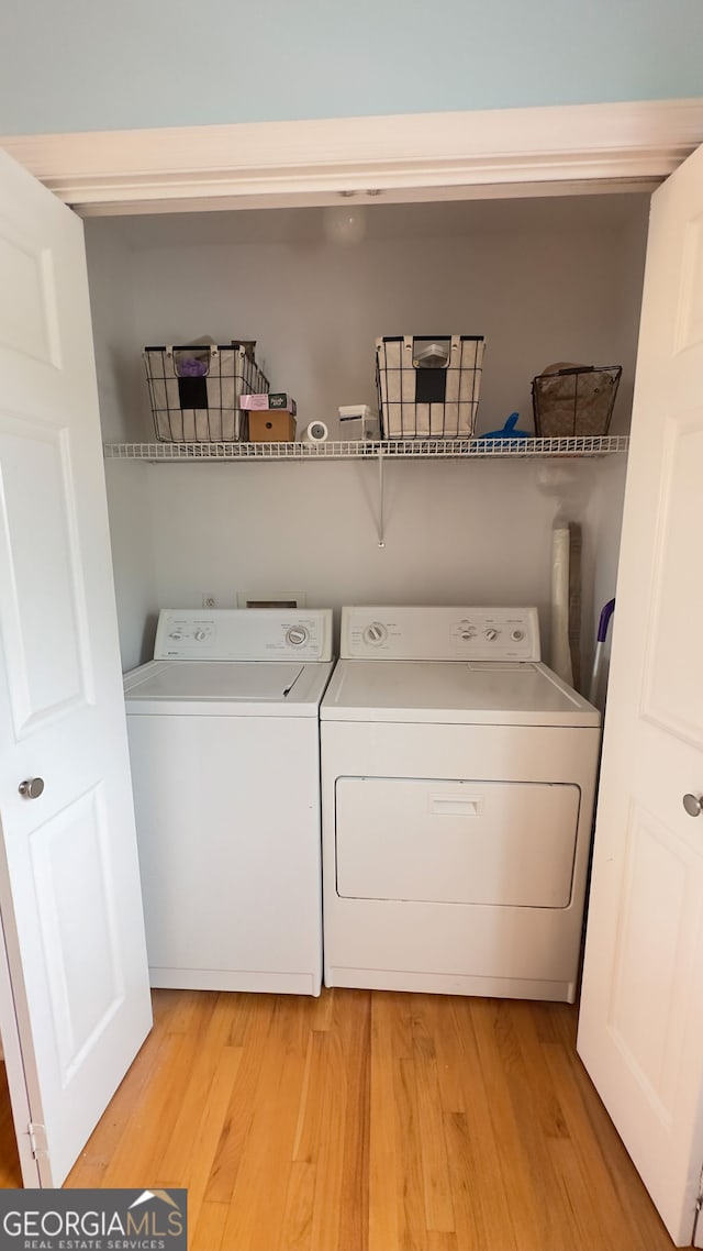 laundry room featuring light hardwood / wood-style floors and separate washer and dryer