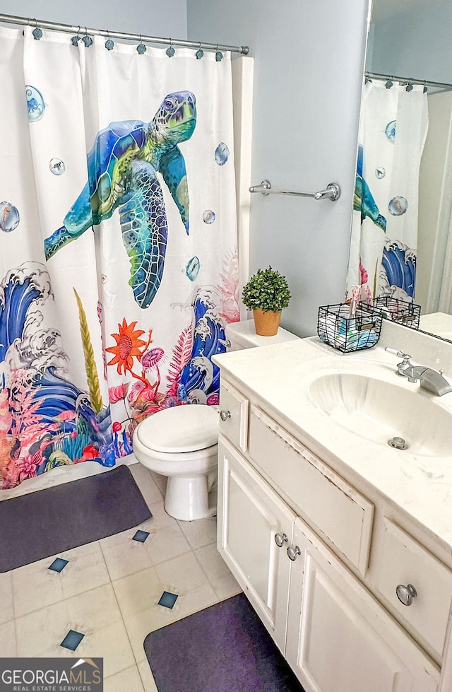 bathroom featuring a shower with curtain, vanity, tile patterned flooring, and toilet