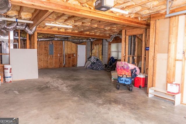 garage with a garage door opener and electric panel