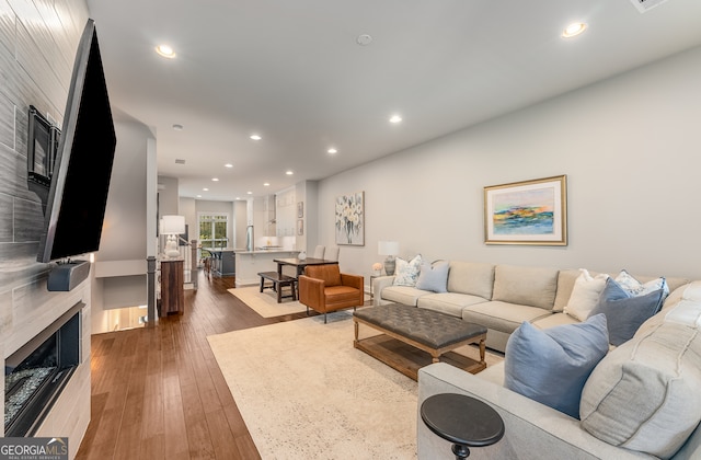 living room with a fireplace and dark wood-type flooring