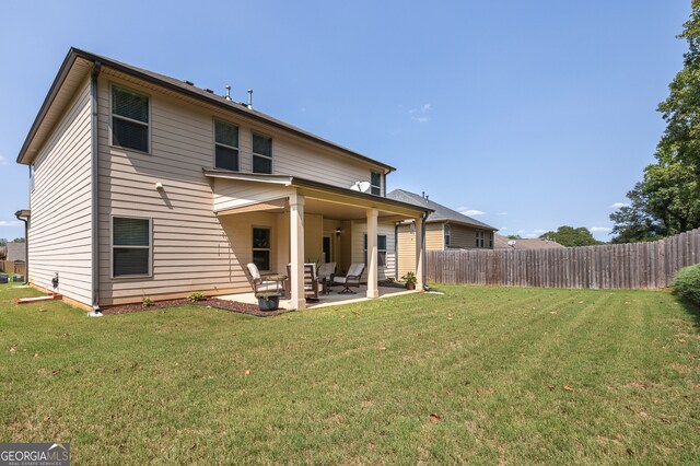 back of property featuring a lawn and a patio area