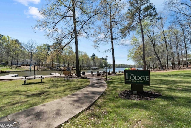 view of home's community with a water view and a yard