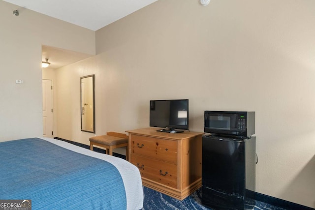 bedroom with black refrigerator