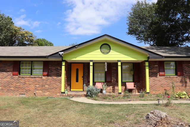 ranch-style home featuring a front lawn and covered porch