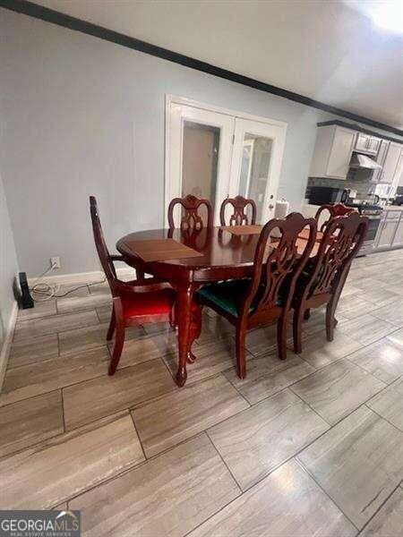 dining area featuring light hardwood / wood-style flooring and ornamental molding