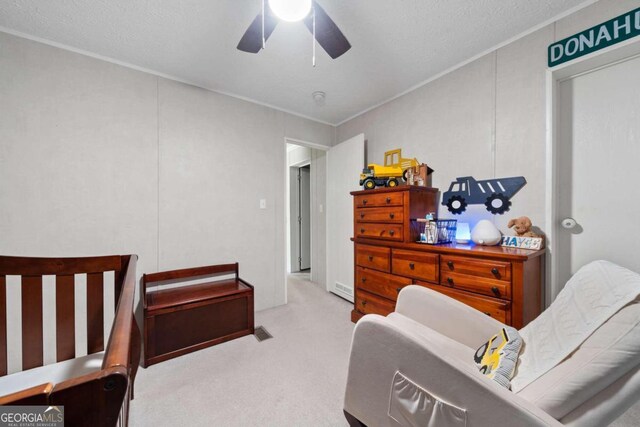 carpeted bedroom featuring a textured ceiling and ceiling fan