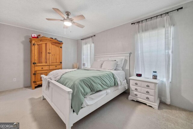 carpeted bedroom featuring a textured ceiling and ceiling fan