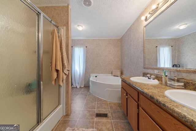 bathroom with plus walk in shower, plenty of natural light, a textured ceiling, and vanity