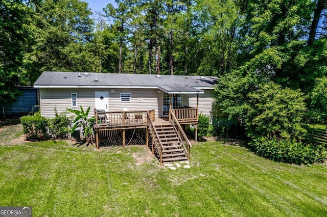 rear view of house with a lawn and a wooden deck