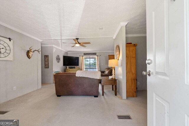 carpeted living room with a textured ceiling, crown molding, and ceiling fan