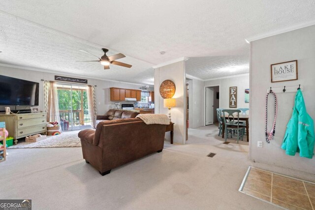 carpeted living room featuring ceiling fan, ornamental molding, and a textured ceiling